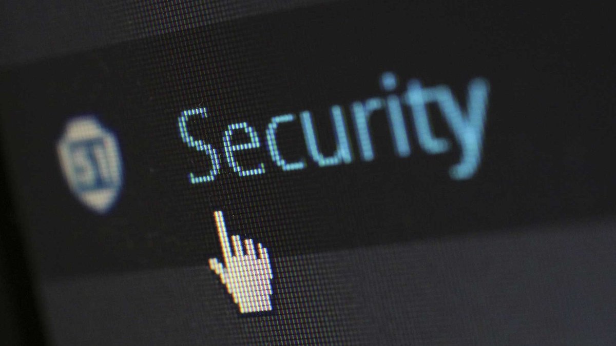 A close-up of a computer screen used as a stock image to represent data protection. The word “Security” is written in blue text against a black background. The cursor is pointing at the text.