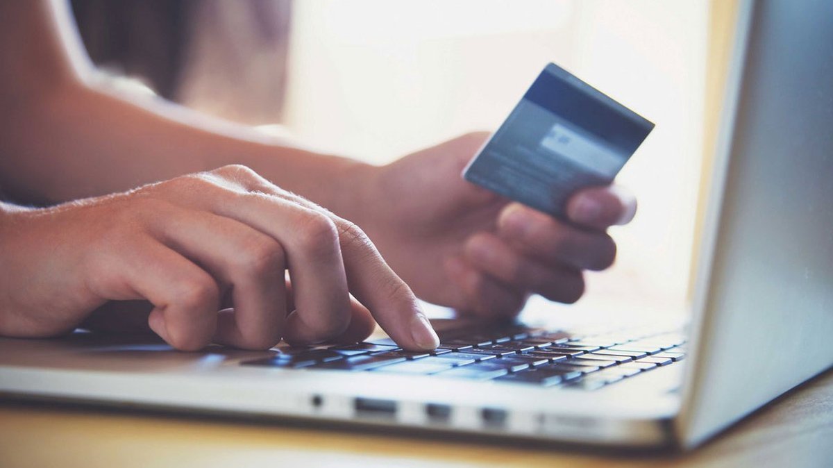A person enters their credit card details to make a payment in an online shop.